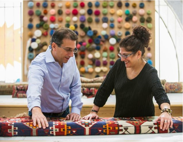 Rug dealers assesing the quality of a flat-weave rug.